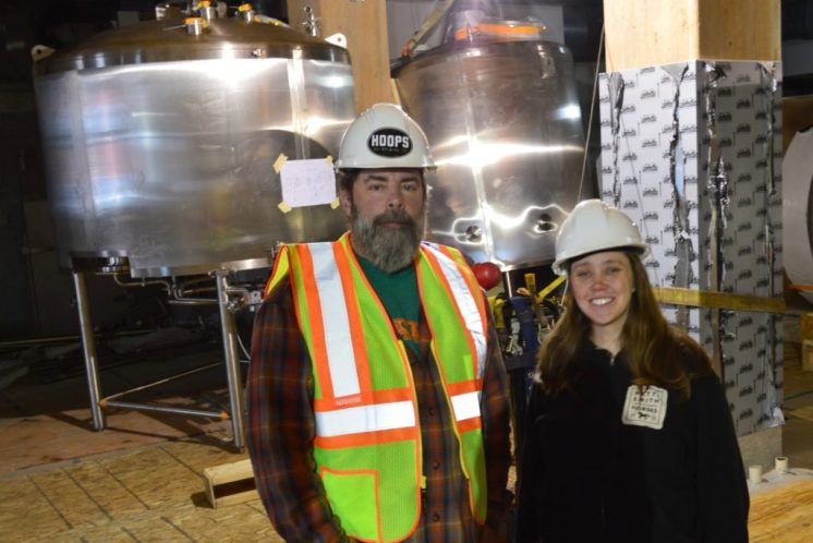 Hoops Brewing founder Dave Hoops and Head Brewer Melissa Rainville pose in front of recently installed beer kettles. Hoops Brewing plans to open in late May or June.
